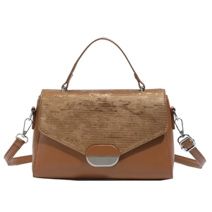 Sac à main marron avec rabat en velours côtelé et fermoir en métal argenté sur fond blanc