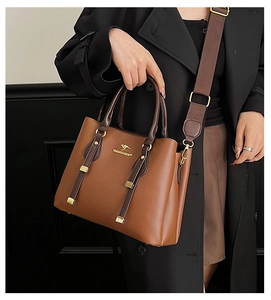 Close-up of brown litchi grain leather tote bag with gold kangaroo logo and wide strap