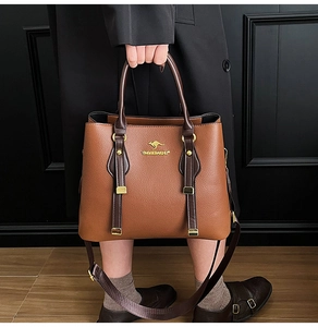 Detail of a brown lychee pattern leather tote with golden kangaroo logo and hardware
