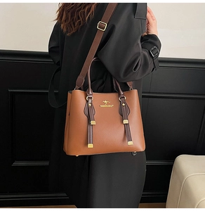 Litchi texture leather tote bag detail with kangaroo logo and gold-tone hardware