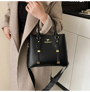 Detail of black lychee grain leather tote bag with gold kangaroo logo and wide strap