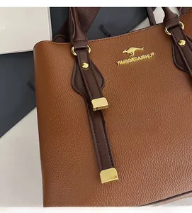 Close-up of brown litchi pattern leather handbag with gold kangaroo logo and rivets