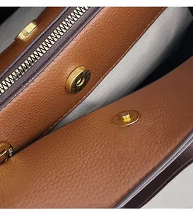 Detail of lychee pattern leather handbag with gold magnetic buckle and fabric lining
