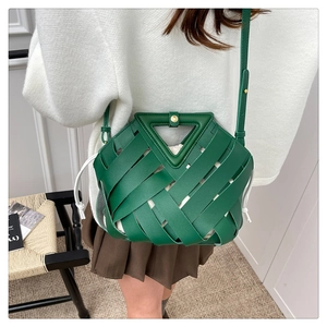 Borsa a secchiello in pelle intrecciata verde con manico a triangolo indossata dalla modella