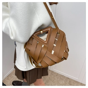 Dettaglio della borsa in pelle intrecciata marrone con manico a triangolo e fodera