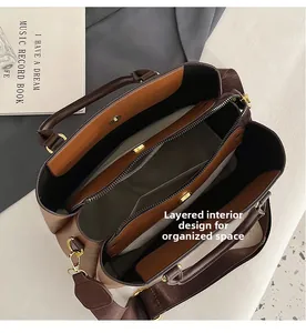 Internal view of brown leather handbag featuring multi-layer compartments and zip pocket