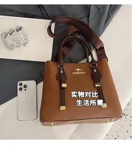 Detailed top view of a brown textured leather tote bag with gold metal kangaroo logo and strap