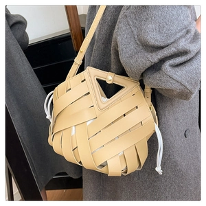Dettaglio borsa a secchiello intrecciata beige con manico triangolare e coulisse