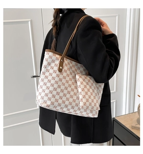 Detail van een luxe witte monogram tote bag met bijpassend etui en bruine leren riemen