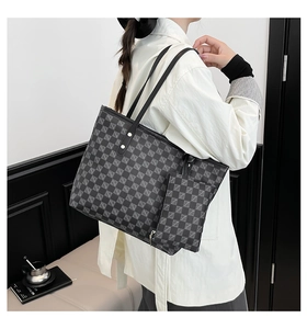 Detail van de grijs geruite shopper met bijpassend etui gedragen door het model