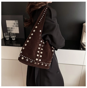 Détail du sac à bandoulière en daim marron avec rivets argentés et style bohème