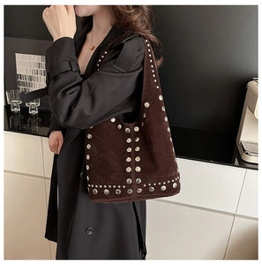 Détail du sac à bandoulière en daim marron foncé orné de rivets métalliques argentés