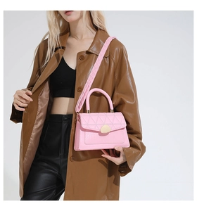Détail du sac bandoulière rose avec coutures matelassées et textures à motif crocodile