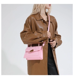 Detail of pink quilted leather bag with crocodile pattern and golden teardrop clasp