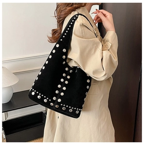 Gros plan du sac hobo vintage noir mat avec rivets argentés porté par un mannequin