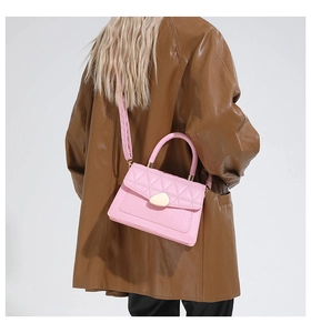 Vue détaillée du sac bandoulière matelassé rose avec finitions dorées sur un mannequin
