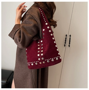 Dettaglio della borsa hobo in pelle scamosciata bordeaux con borchie argentate sulla spalla