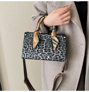 Detail of grey leopard print handbag with silk scarf handle and wide shoulder strap