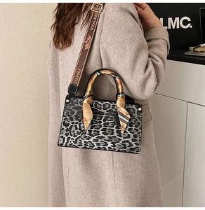Detail of leopard print handbag with silk scarf handle and wide patterned shoulder strap