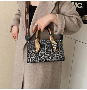 Detail of leopard print handbag with silk scarf handle and branded wide shoulder strap