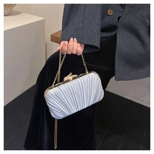 Close-up of elegant pleated satin evening clutch with metallic chain and clasp detail