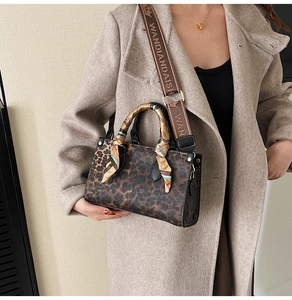 Detail of leopard print crossbody bag with silk scarf handle and wide textile strap