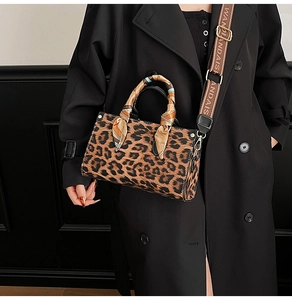 Detail of leopard print crossbody bag featuring silk scarf handle and wide branded strap