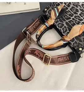 Detail of leopard print handbag with silk scarf handle and adjustable strap