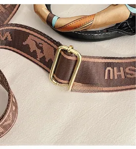 Detailed view of brown jacquard strap with gold-tone hardware on leopard print handbag