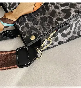 Detail of leopard print crossbody bag with gold hardware and silk scarf handle wrap