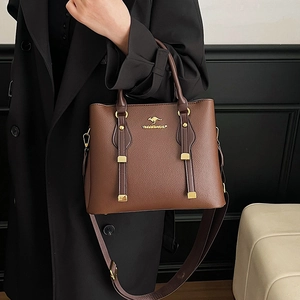 Brown lychee leather tote bag with gold hardware and adjustable strap shown on a model