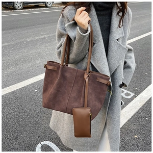 Detail of suede tote bag with matching coin purse shown on grey cashmere coat