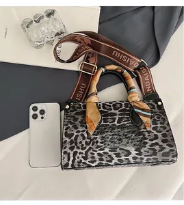 Top view of leopard print handbag with silk-wrapped handles and matching wide shoulder strap