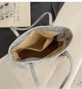 Detail view of large tote bag interior with zipper compartments and beige lining