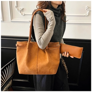 Detail of camel suede tote bag and matching zipper pouch in minimalist city style