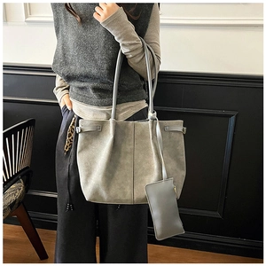 Detail view of a large grey suede tote bag set with matching inner pouch for women