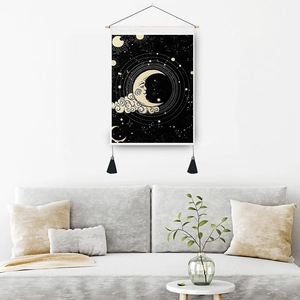 Astrological sun and moon wall tapestry with wooden rod and black tassels on white wall