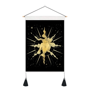 Détail de tapisserie bohème avec déesse dorée, tringle en bois et pompons noirs