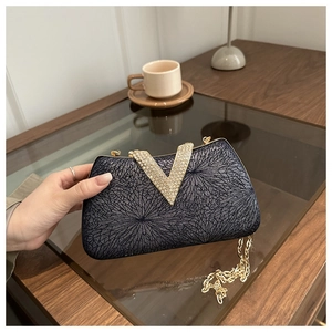Detail of glitter evening clutch bag with sparkling diamond V-shape gold buckle