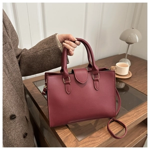 Dettaglio borsa in pelle bordeaux con patta a V e trama martellata testurizzata