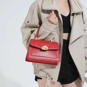 Red quilted leather handbag with gold metal clasp and crocodile texture detail