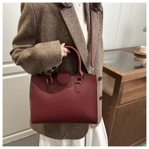 Dettaglio borsa a mano bordeaux in pelle PU martellata con finiture in oro chiaro