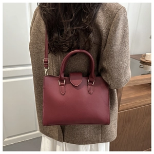 Burgundy litchi grain leather tote bag worn as a shoulder bag on a model back view