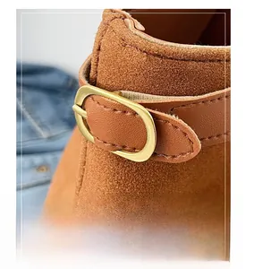 Close-up of suede material texture with gold oval buckle and brown leather strap detail