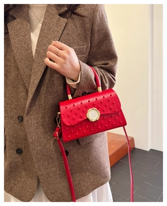 Détail du sac bandoulière rouge matelassé avec fermoir doré et bandoulière en cuir