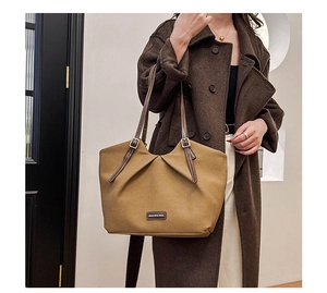 Detail of khaki canvas tote with brown leather strap and Fashion & Bags label