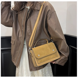 Brown leather and suede crossbody bag shown with a leather jacket for a retro autumn style