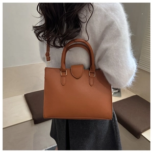 Dettaglio borsa tote in pelle martellata caramello con finiture in metallo dorato