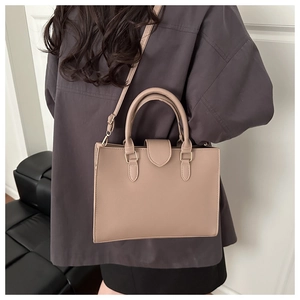 Detailed view of apricot pebbled leather handbag with sturdy handles and shoulder strap