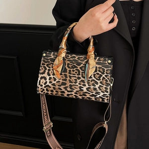 Leopard print crossbody bag with silk scarf handle and wide strap on fashion model